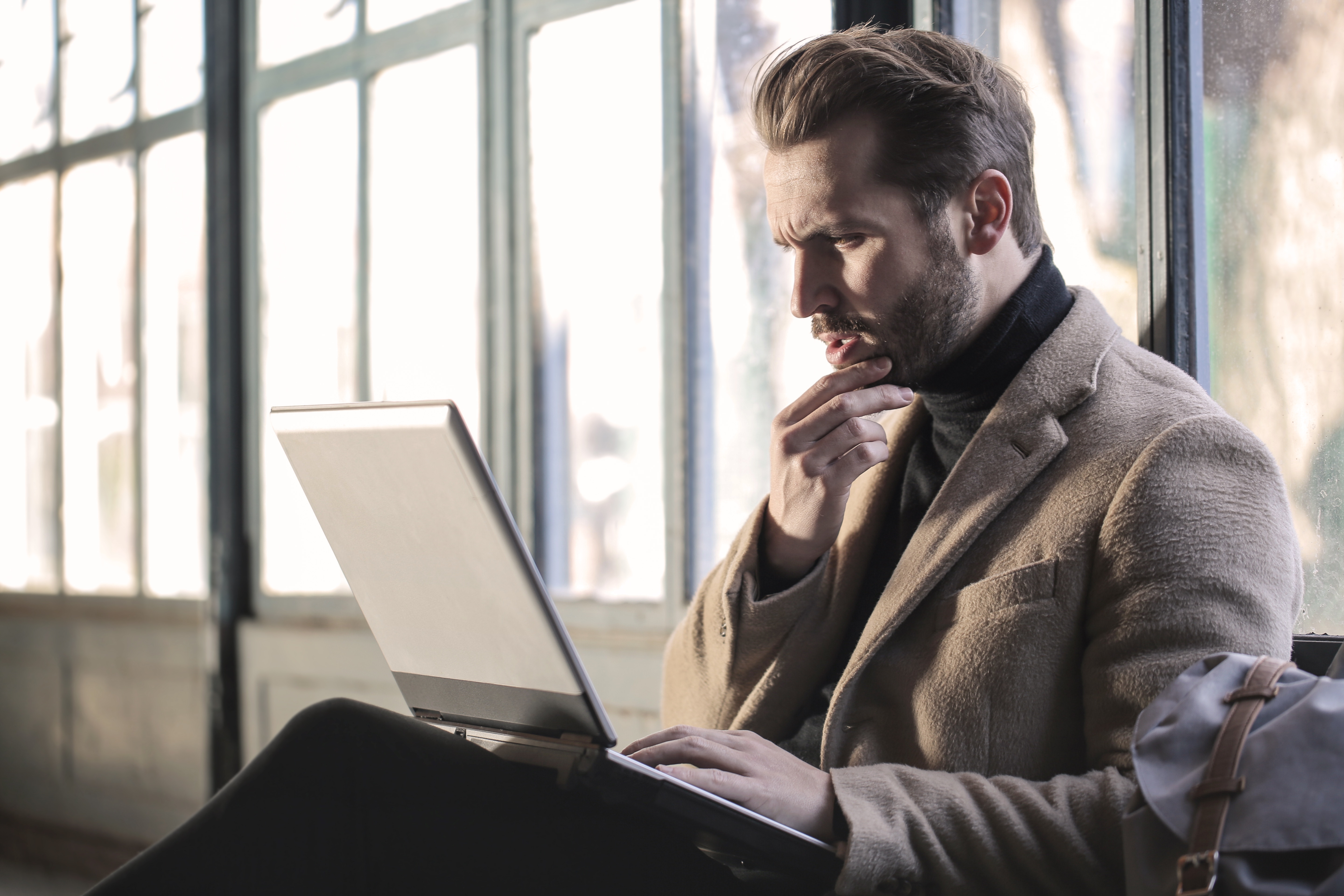 Image of someone staring at a laptop with concern.